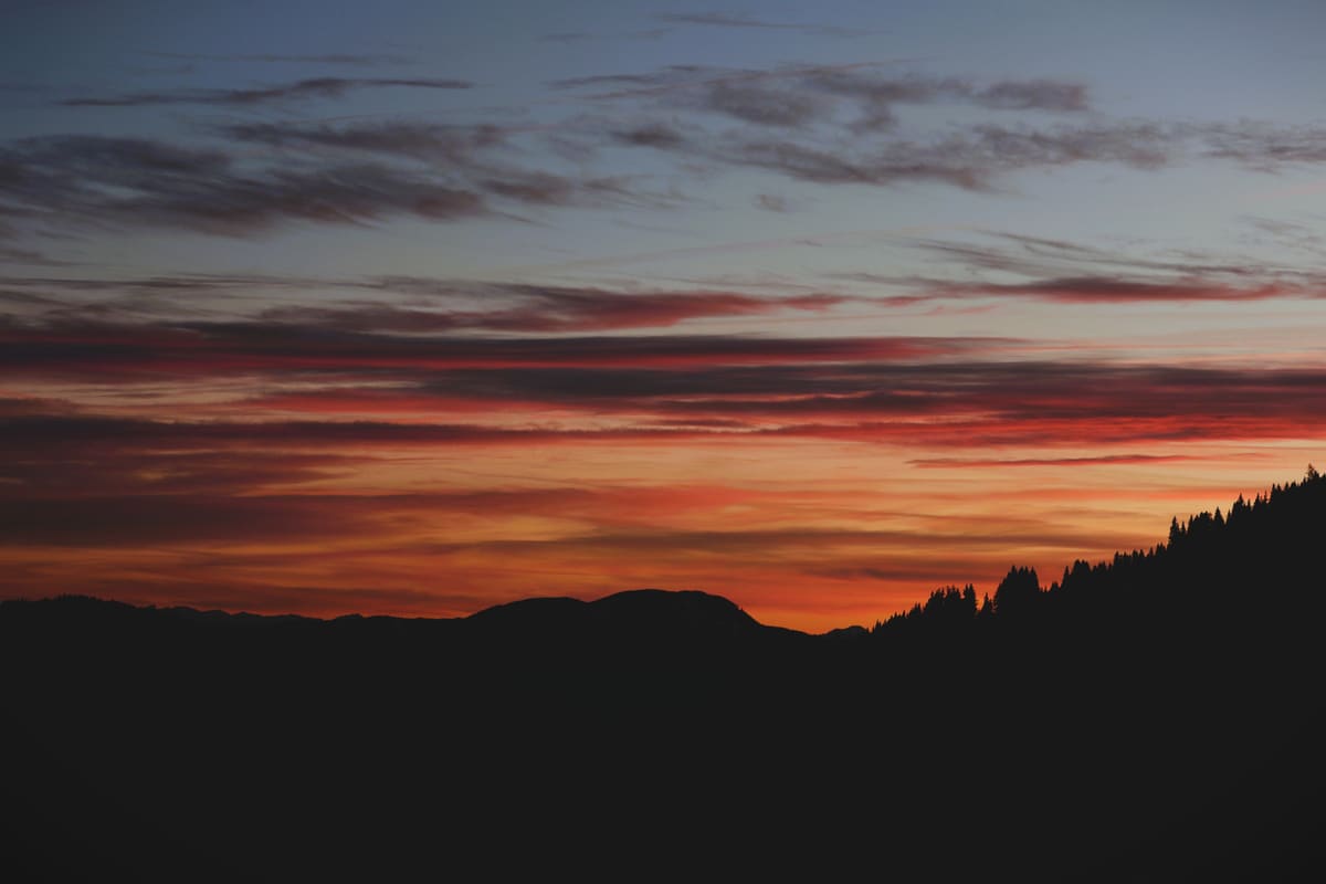 Breathtaking sunset showcasing vibrant colors over silhouetted mountains, perfect for serene and dramatic visuals.